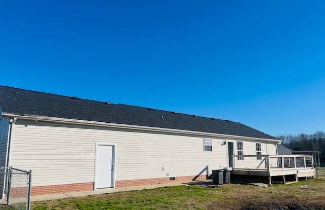 rear view of property with a lawn and a wooden deck