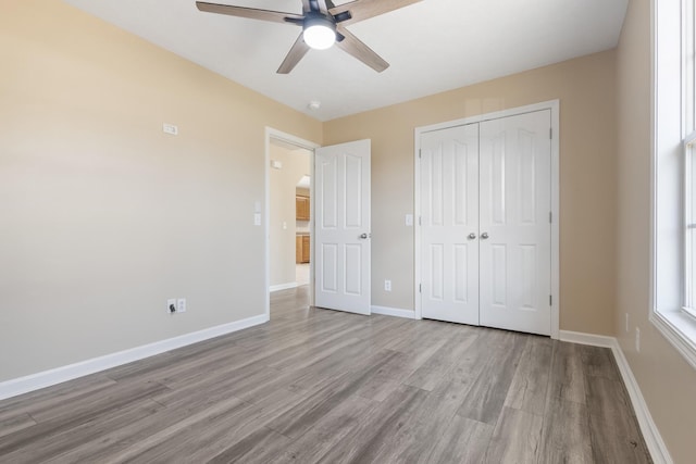 unfurnished bedroom featuring ceiling fan, a closet, and light hardwood / wood-style flooring
