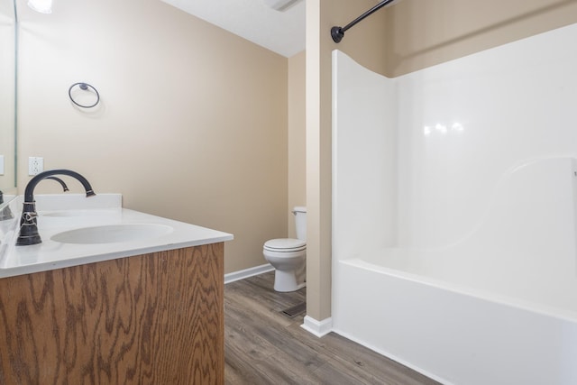 full bathroom featuring vanity, hardwood / wood-style flooring, shower / washtub combination, and toilet