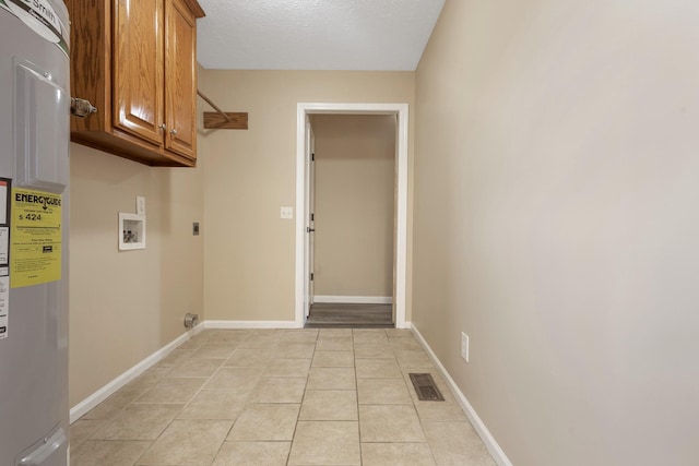 laundry area featuring water heater, cabinets, washer hookup, light tile patterned floors, and electric dryer hookup