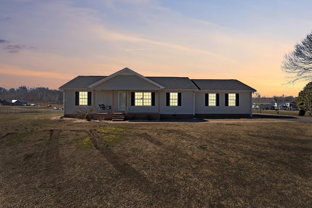 ranch-style house with a porch and a yard