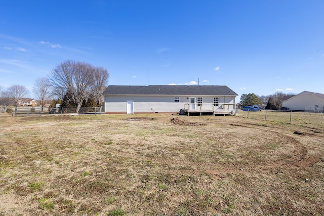 rear view of property with a deck and a lawn