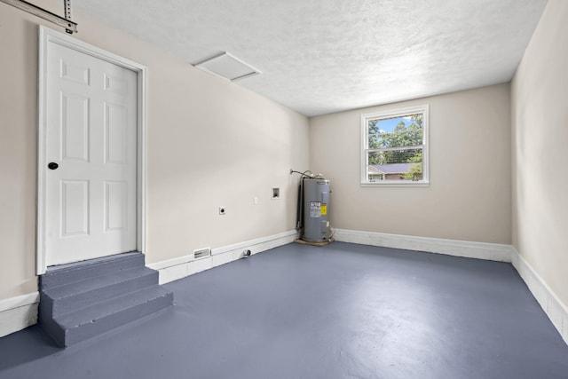 interior space with a textured ceiling and water heater