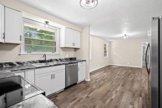 kitchen featuring stainless steel appliances, white cabinetry, and sink