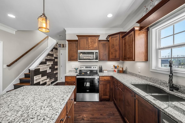 kitchen with light stone countertops, appliances with stainless steel finishes, crown molding, sink, and pendant lighting