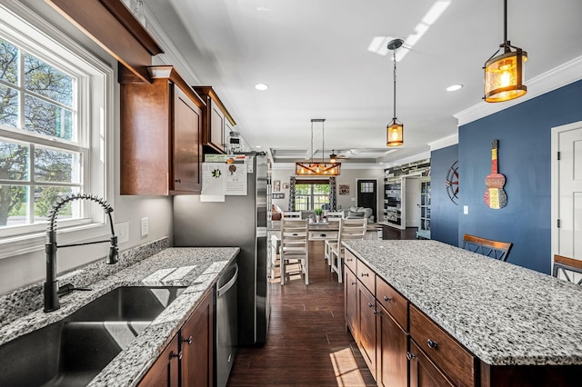 kitchen with a center island, appliances with stainless steel finishes, hanging light fixtures, and sink