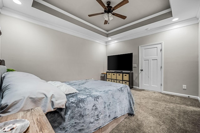 carpeted bedroom with a tray ceiling, ceiling fan, and ornamental molding