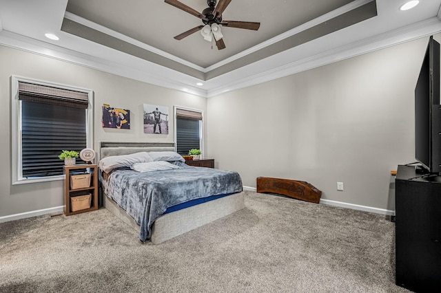 carpeted bedroom with ceiling fan, crown molding, and a tray ceiling