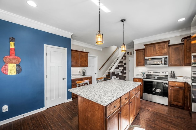 kitchen with a center island, hanging light fixtures, dark hardwood / wood-style flooring, crown molding, and appliances with stainless steel finishes