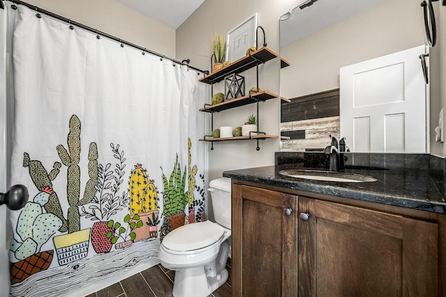 bathroom featuring vanity, toilet, and wooden walls