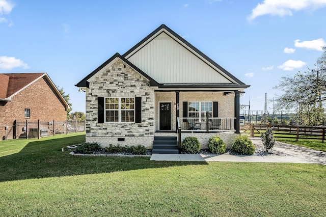 craftsman inspired home featuring covered porch and a front yard