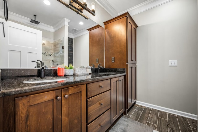 bathroom featuring vanity, ornamental molding, and tiled shower