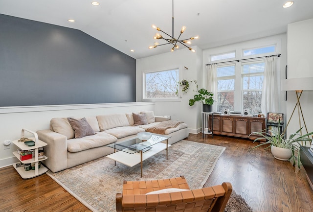 living room with vaulted ceiling, an inviting chandelier, and dark wood-type flooring