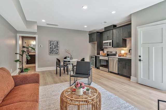 living room featuring sink and light hardwood / wood-style floors