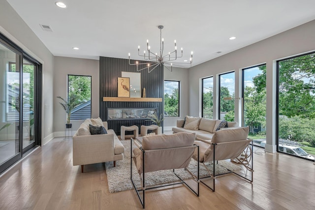 living room with baseboards, light wood-type flooring, visible vents, and recessed lighting