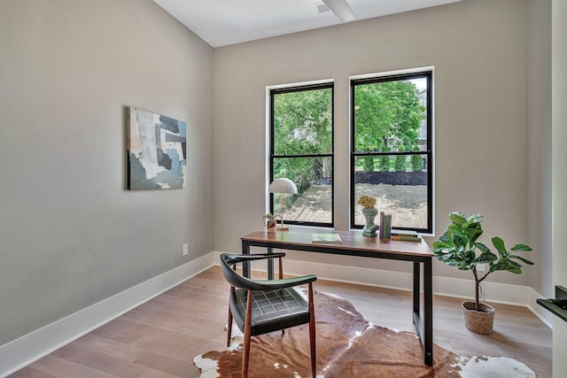 home office with light hardwood / wood-style floors