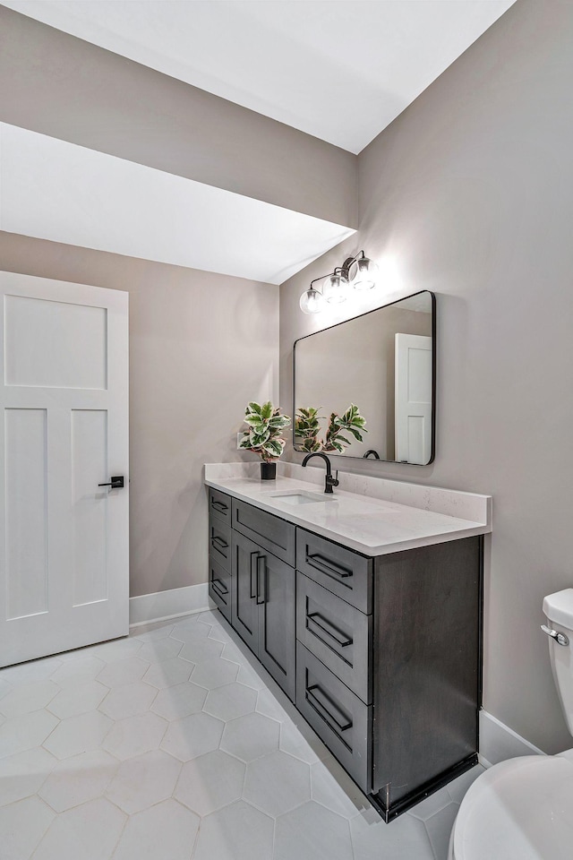 bathroom with tile patterned flooring, vanity, and toilet