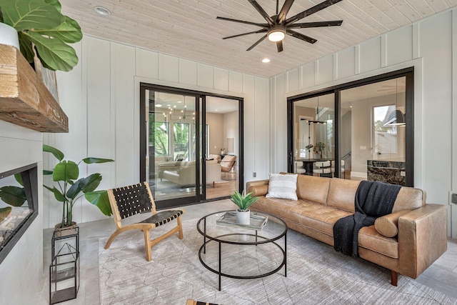 interior space featuring ceiling fan, wooden walls, and wood ceiling