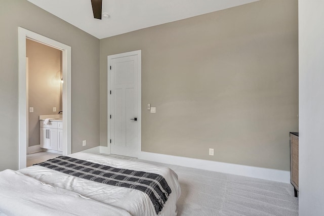 carpeted bedroom featuring ensuite bath and ceiling fan