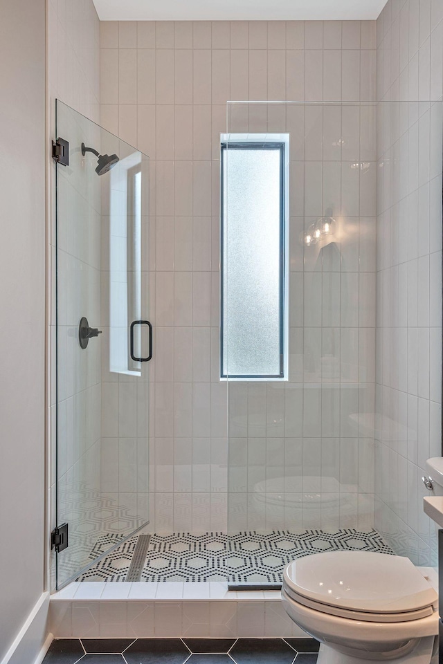 bathroom featuring tile patterned floors, an enclosed shower, and toilet