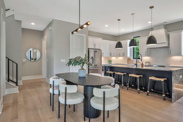 dining space with light hardwood / wood-style floors and sink