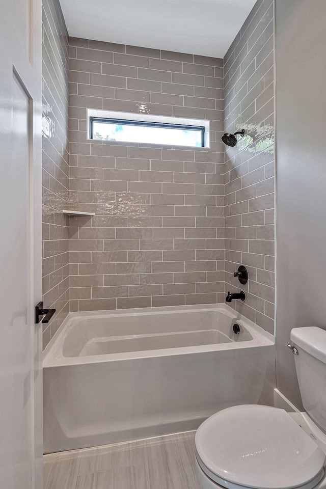 bathroom featuring toilet, plenty of natural light, and washtub / shower combination