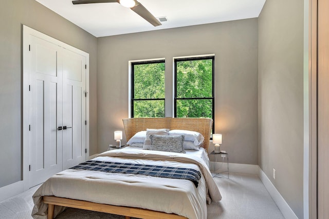 carpeted bedroom with ceiling fan and a closet