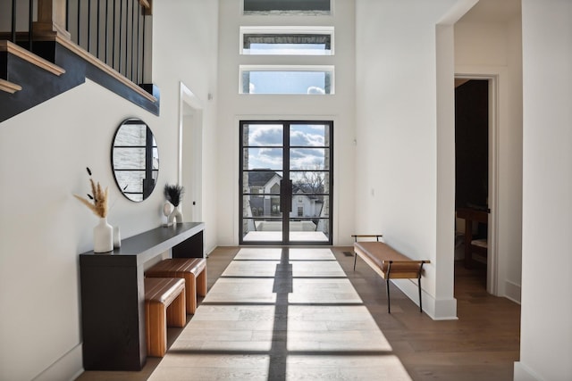 entryway featuring hardwood / wood-style floors and a high ceiling