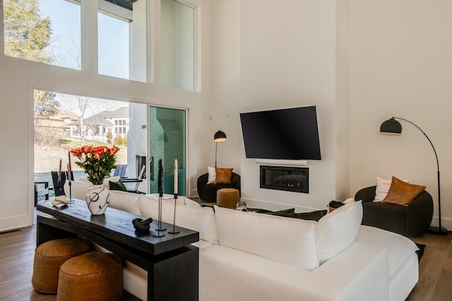 living room with wood-type flooring and a towering ceiling