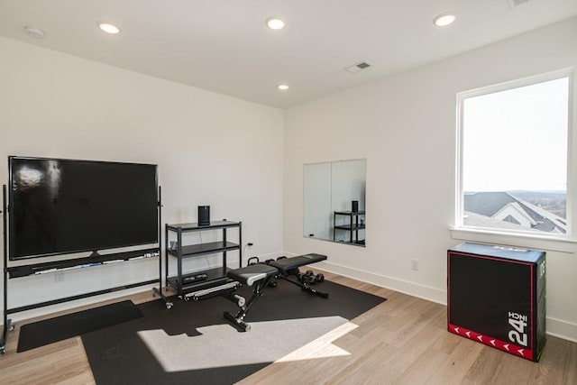 workout area with light hardwood / wood-style floors