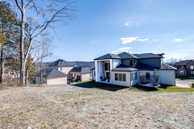 view of front of home with a trampoline and a front lawn