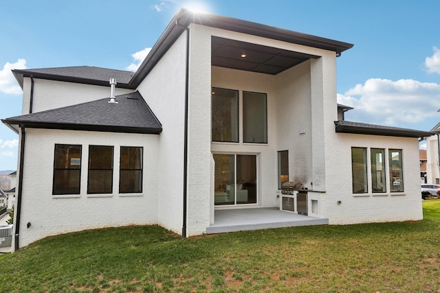 back of property featuring a lawn, area for grilling, and a patio area