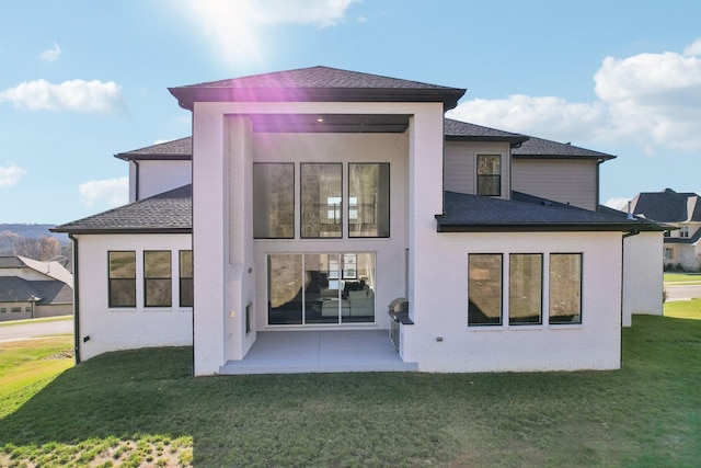 rear view of house with a lawn and a patio