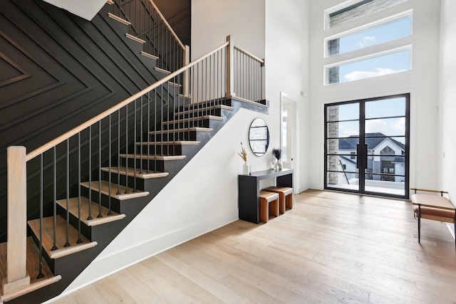 stairs featuring hardwood / wood-style floors and a towering ceiling