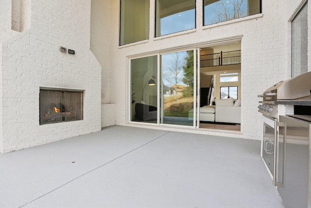 view of patio featuring an outdoor brick fireplace