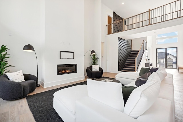 living room featuring light hardwood / wood-style floors and a high ceiling