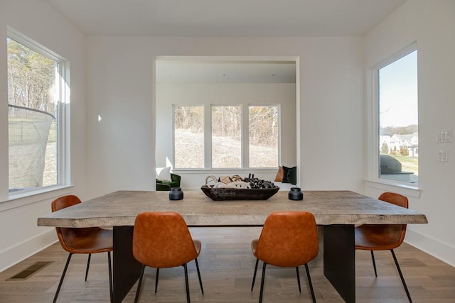 dining space with hardwood / wood-style floors and a healthy amount of sunlight