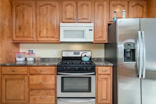 kitchen featuring dark stone counters and stainless steel appliances