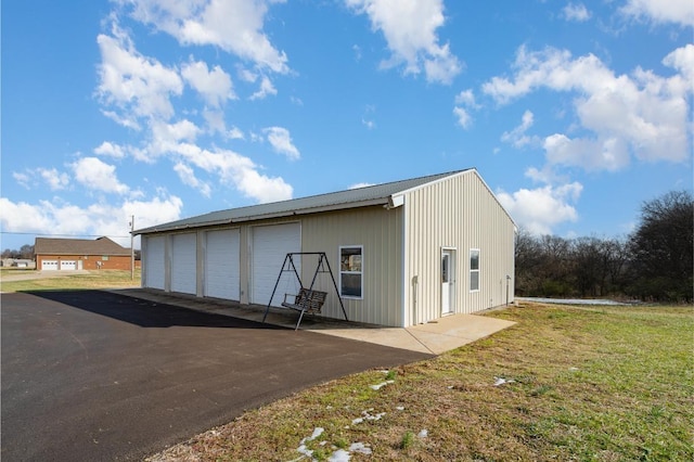 view of outbuilding featuring a lawn and a garage