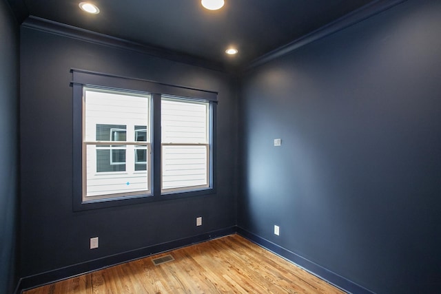 unfurnished room featuring ornamental molding and hardwood / wood-style floors