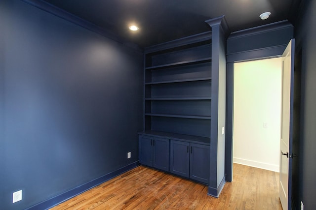 interior space featuring hardwood / wood-style floors and crown molding