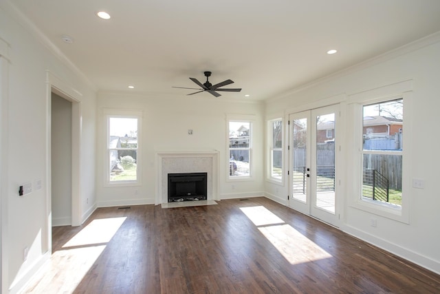 unfurnished living room with crown molding, plenty of natural light, and french doors