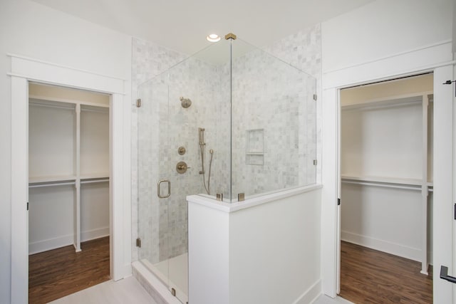 bathroom featuring a shower with door and wood-type flooring