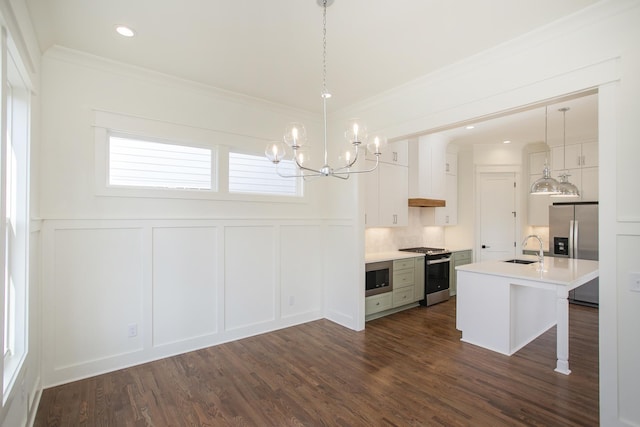 kitchen with pendant lighting, sink, white cabinets, a kitchen island with sink, and stainless steel appliances