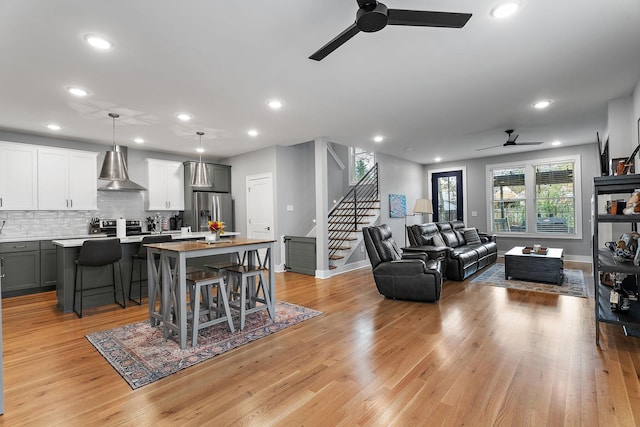 living room featuring ceiling fan and light hardwood / wood-style floors