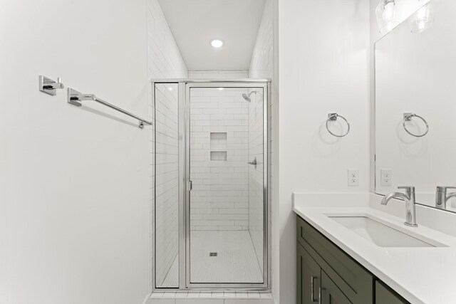 bathroom featuring walk in shower and vanity