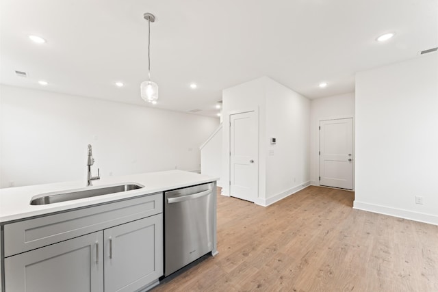 kitchen with light hardwood / wood-style floors, gray cabinets, decorative light fixtures, dishwasher, and sink