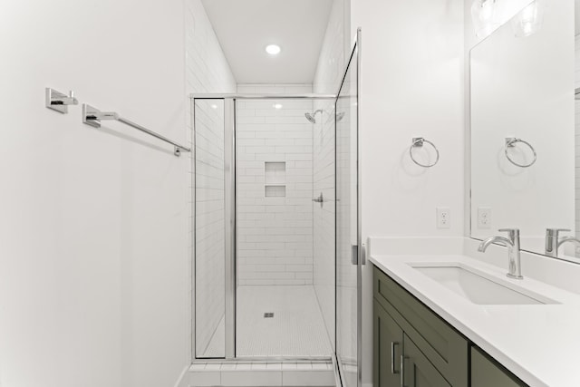 bathroom with an enclosed shower, vanity, and tile patterned flooring