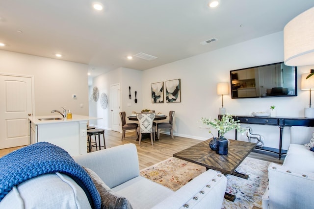 living room featuring light wood-type flooring and sink