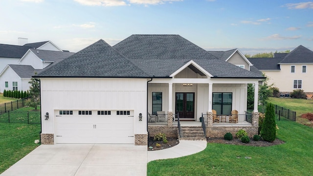 view of front of house with a porch, a garage, and a front lawn